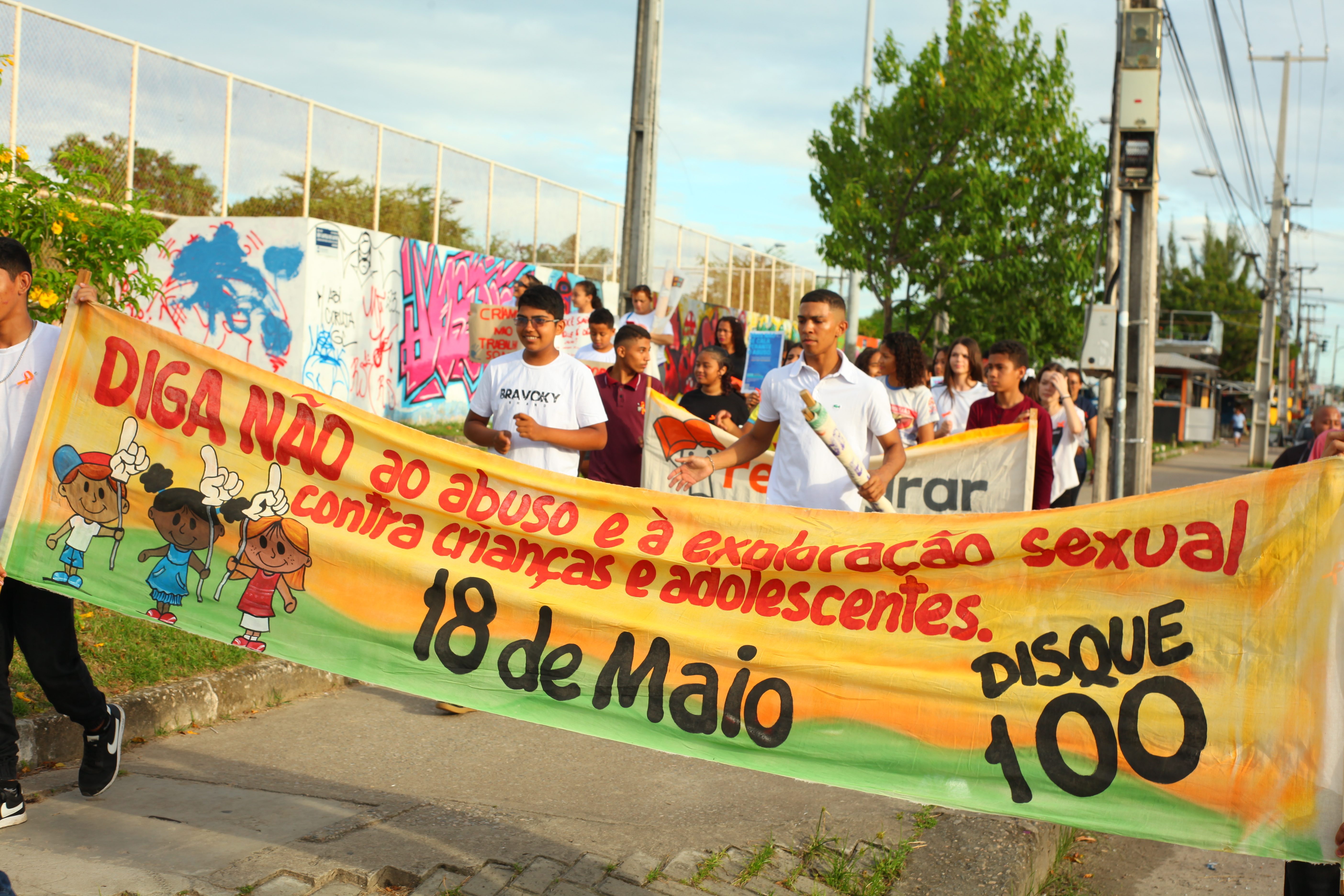 grupode jovens segurando um cartaz em uma caminhada na rua 